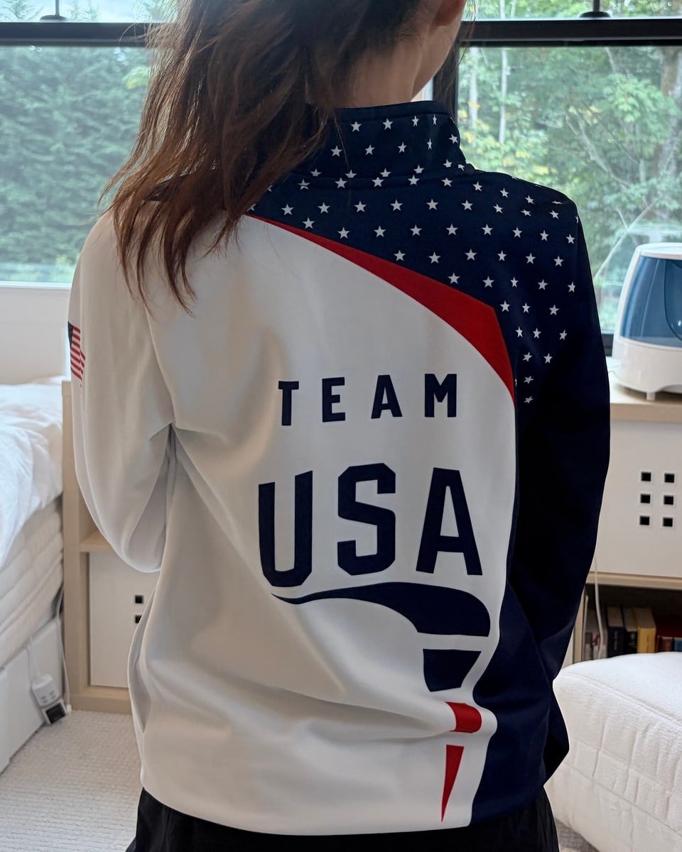 Detail of a red, white, and blue team jacket photographed from behind.