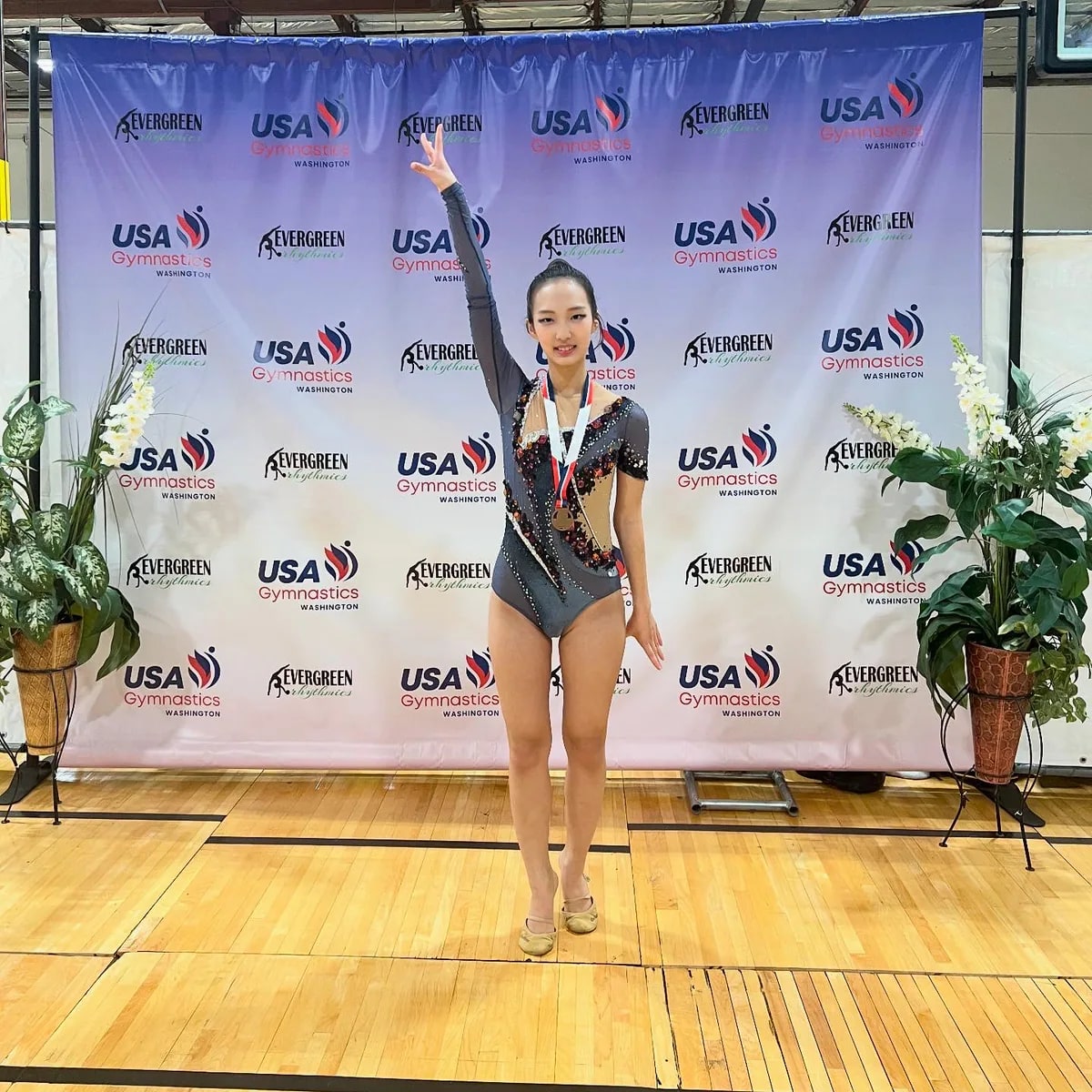Lynn wearing a medal in front of a USA Gymnastics Washington backdrop.